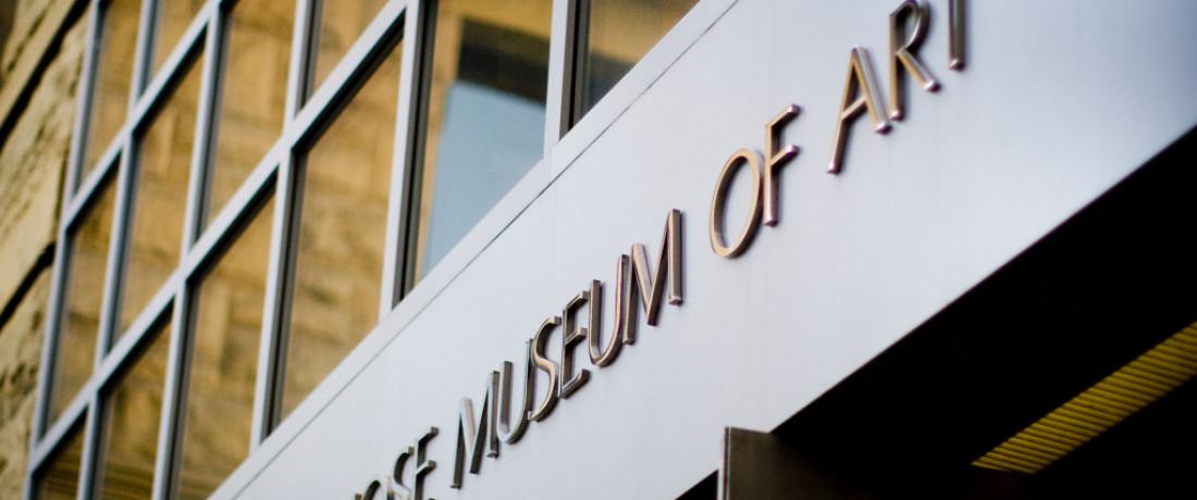 Close-up of the San José Museum of Art entrance, showing windows and "Museum of Art" from a low angle.