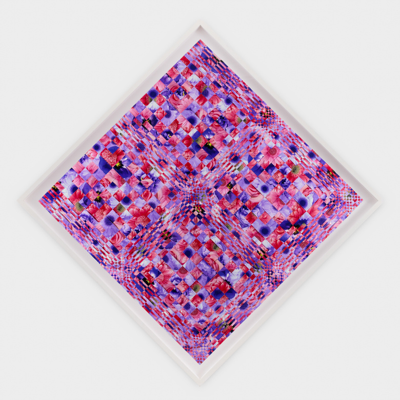 A diamond shaped painting in a white frame hangs on a white wall. The mosaic-like image is composed of reds, fuschias, dark blues, and whites in an all-over pattern suggestive of—but not quite identifiable as—flowers. Faint lines throughout the image suggest a woven quality.
