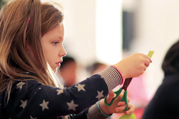 Child cutting paper during an art activity.